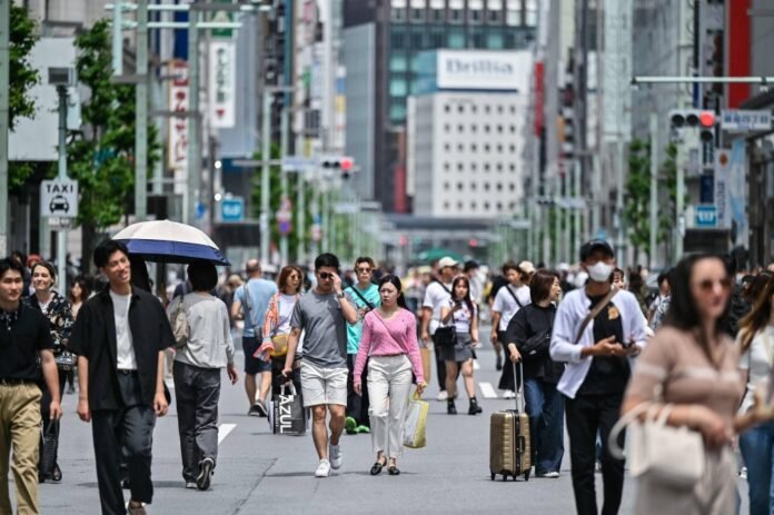 Tourists and locals stroll along Tokyo's Ginza shopping district where some roads are closed off for pedestrians due to the national holiday on April 29. 