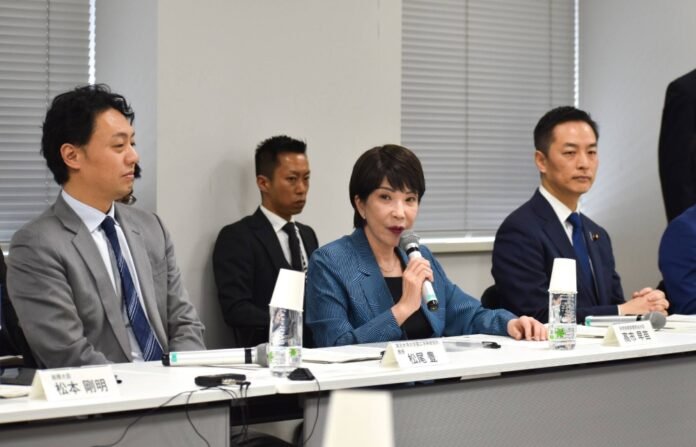 Science and technology policy minister Sanae Takaichi (center) speaks at a meeting of the government's AI Strategy Council on Wednesday. 