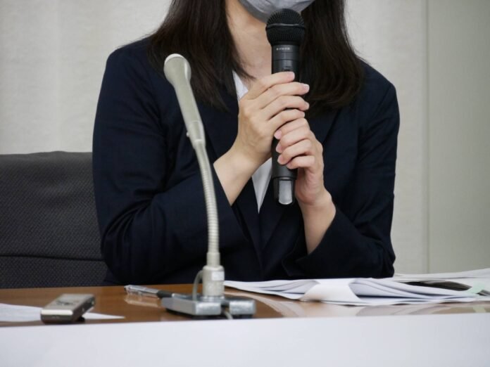 The plaintiff in an indirect gender discrimination case speaks at a news conference after winning the case in Tokyo on Monday. 