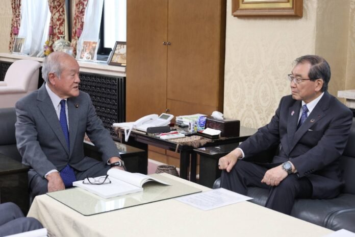 Finance Minister Shunichi Suzuki receives a draft proposal from Keidanren Chairman Masakazu Tokura (right) for a fiscal council meeting in Tokyo on Tuesday. 
