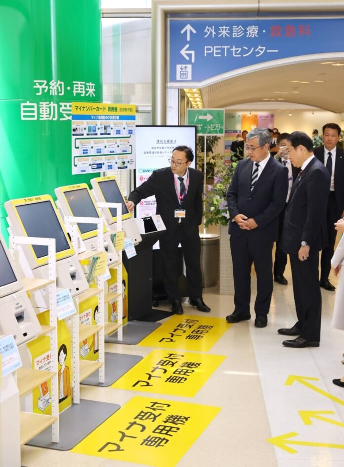 Prime Minister Fumio Kishida (right) views My Number card readers during an inspection of Nihonkai General Hospital in Sakata, Yamagata Prefecture, on Sunday. 