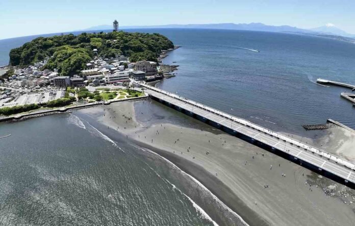  Low tide connects Enoshima Island directly to Honshu;  Tourists enjoy natural phenomenon

