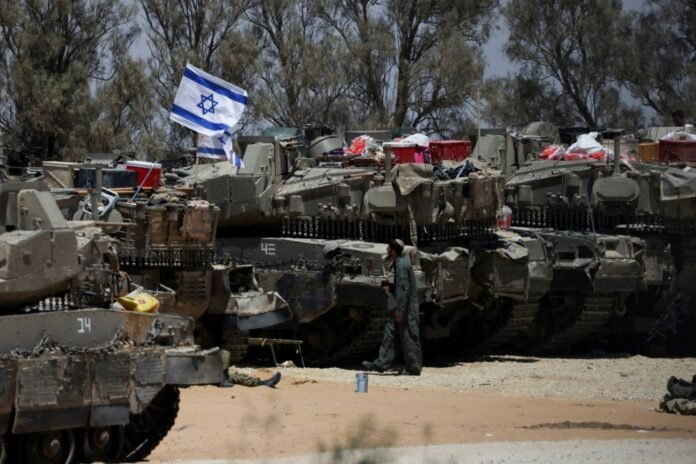 An Israeli soldier walks close to military vehicles near Israel's border with Gaza in southern Israel on May 29. 