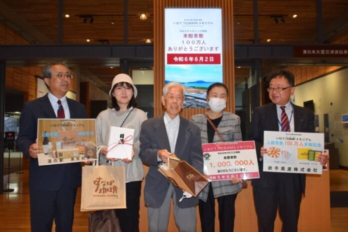 Shinsaku Otomo (center) became the one millionth visitor to the Iwate Tsunami Memorial Museum on Sunday. 