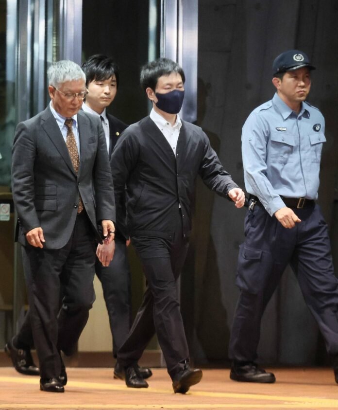 Lower House lawmaker Masatoshi Akimoto (second from right) leaves the Tokyo Detention House in Tokyo's Katsushika Ward on Thursday. 