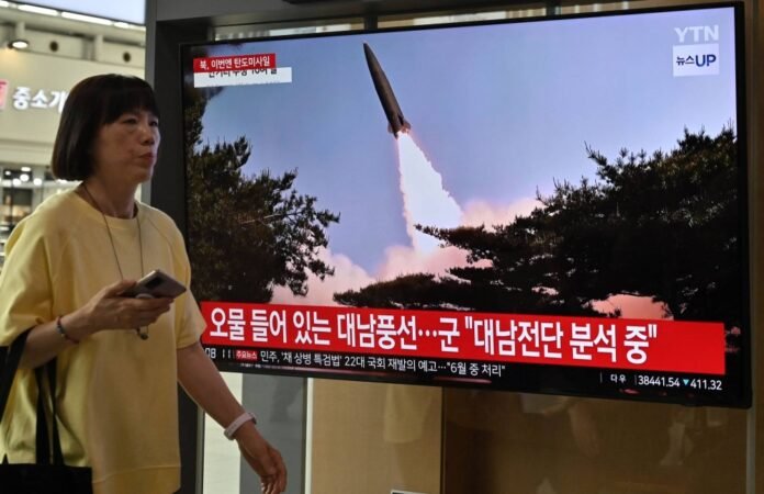 A woman walks past a television screen showing a news report on a North Korean missile launch, at the main rail station in Seoul on May 30. 