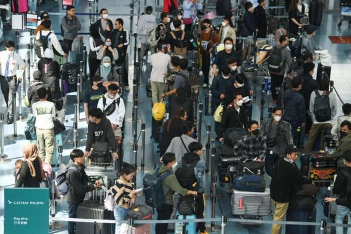 Travelers in a departure hall at Haneda Airport in Tokyo on April 26. For environmentalists, the resurgence of tourism will be met with dismay as it drives an accompanying surge in carbon emissions, but for the oil industry, the revival is a welcome boost.  