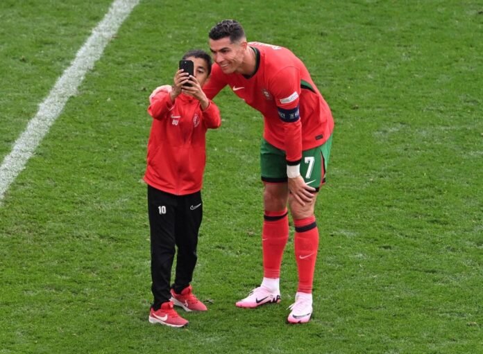 Portugal's Cristiano Ronaldo takes a selfie with a fan during his team's match against Turkey during Euro 2024 in Dortmund, Germany, on Saturday. 