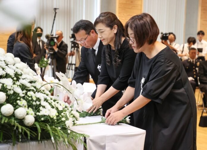 People offer flowers during a memorial ceremony in Hitoyoshi, Kumamoto Prefecture, on Sunday to pray for those killed due to heavy rains in the area four years ago. 