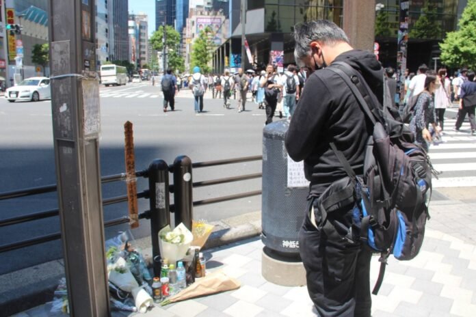 A man pays his respects at an intersection in Akihabara on Saturday, 16 years after a deadly attack left seven people dead and 10 others injured. 
